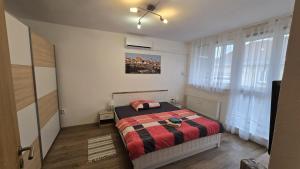 a bedroom with a bed with a red and black blanket at Apartmán u Berušky in Znojmo
