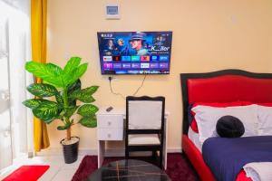 a bedroom with a bed and a tv on the wall at The Haven in Nyeri