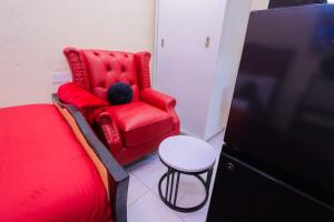 a red chair and a table in a room at The Haven in Nyeri