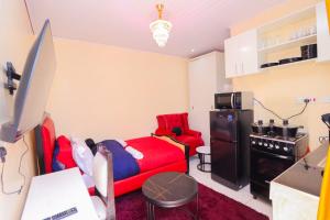 a living room with a red couch and a refrigerator at The Haven in Nyeri