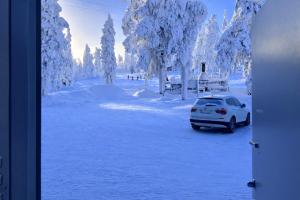 a car parked in a parking lot covered in snow at Sisältää 2x Ruka ranneke - kausikortit kesä&talvi - Vuosselin Helmi C11 in Ruka