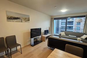 a living room with a couch and a flat screen tv at Christel Residence in Ostend