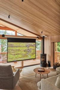a living room with a large screen in a house at Eagle & Marmot, Carezza Dolomites in Carezza al Lago