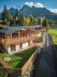 an aerial view of a house with mountains in the background at Eagle & Marmot, Carezza Dolomites in Carezza al Lago