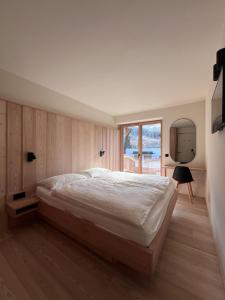 a bedroom with a large bed and a window at Eagle & Marmot, Carezza Dolomites in Carezza al Lago