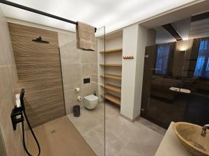 a bathroom with a toilet and a glass shower at Guesthouse Bonheure in Bruges
