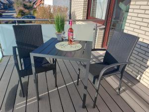 a table with a bottle of wine and two chairs at Ferienwohnung Bergstraße in Extertal +10 photos