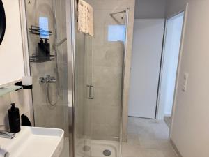 a bathroom with a glass shower and a sink at Liya Apartments in Aiterhofen +70 photos