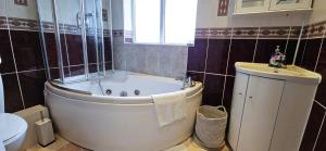 a bathroom with a large tub and a sink at Spacious Home Near Wembley, Free Parking, Close to Tube, Garden in Pinner +14 photos