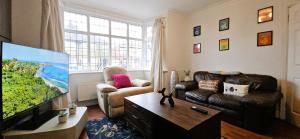 a living room with a large flat screen tv at Spacious Home Near Wembley, Free Parking, Close to Tube, Garden in Pinner