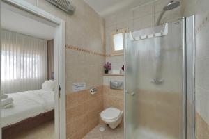 a bathroom with a shower and a toilet and a bed at Private jacuzzi suite rosh pina in Rosh Pinna