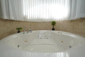 a large white tub in a bathroom with a window at Private jacuzzi suite rosh pina in Rosh Pinna
