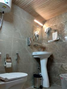 a bathroom with a sink and a toilet at Peaks n Pines in Nainital +21 photos