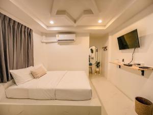 a white bedroom with a bed and a television at KohLan Hansa in Ko Larn +28 photos
