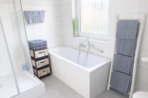 a white bath tub in a bathroom with a window at Bali Spirit - Toplage Usingen in Usingen