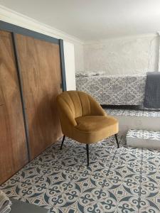 a brown chair sitting in a room next to a door at Studio D in Willemstad