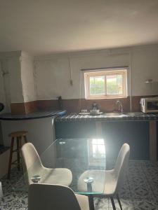 a kitchen with two chairs and a table and a sink at Studio D in Willemstad