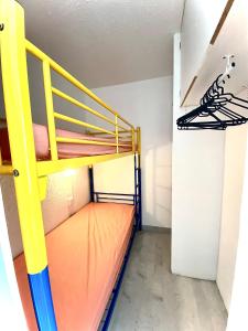a bunk bed in a room with a yellow ladder at appartement T2 cabine cap d'agde in Cap d'Agde