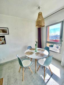 a dining room with a table and chairs and a window at appartement T2 cabine cap d'agde in Cap d'Agde