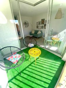 a room with two tables and chairs on a balcony at appartement T2 cabine cap d'agde in Cap d'Agde +3 photos