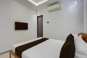 a bedroom with a bed and a tv on the wall at Hotel O Royal Fourtune in Surat
