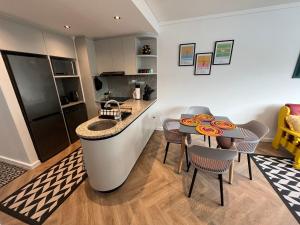 a kitchen with a bar and a table and chairs at The Happy Chameleon in George