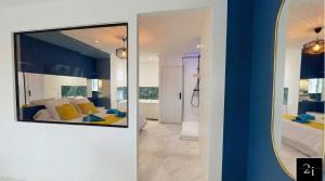 a mirror on a wall next to a bedroom at LE 21 - Suite SPA Premium - Jacuzzi Privatif & Vue Rhône in Vienne +11 photos
