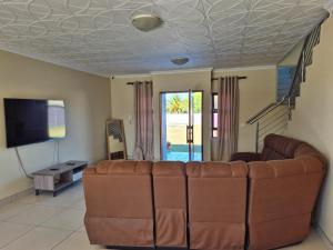 a living room with a couch and a tv at Pemba's residence in Cape Town