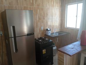 a kitchen with a stainless steel refrigerator and a stove at POUSADA GOLFINHO FLECHEIRAS Ce in Trairi +19 photos
