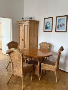 a dining room with a wooden table and wicker chairs at FeWo Seliger am Schloßplatz in Meersburg