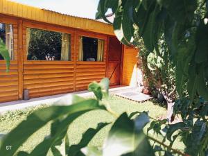 a wooden cabin with a window in a yard at Cabaña azul in Los Antiguos