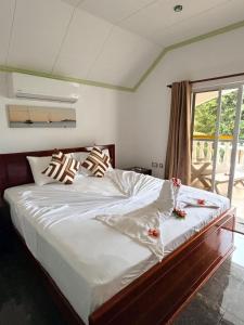 a bedroom with a large bed with flowers on it at Wyn Villa in Praslin
