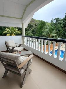 a balcony with a chair and a view of a pool at Wyn Villa in Praslin