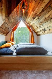 a bed in a room with a large window at Buda 2 in Komjatná