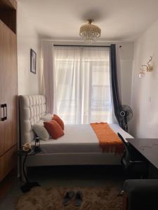 a bedroom with a bed with a window and a chandelier at Sk home in Kiambu