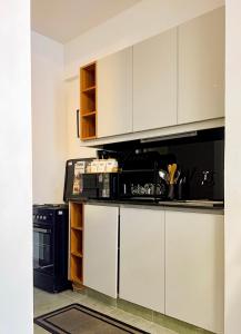 a kitchen with white cabinets and a black appliance at Sk home in Kiambu