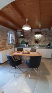a kitchen with a wooden table and two chairs at Casa Bumbara in Vodnjan