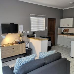 a living room with a couch and a kitchen at Sune's self catering 2 in Worcester