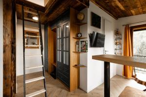 a tiny house with a black door and a desk at Buda 2 in Komjatná