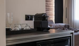 a table with a coffee maker and glasses on it at Golden Island Resorts in Athens