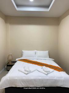 a large white bed with two white towels on it at Neo cafe and hotel 2 in Sathani Maruan