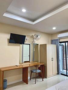 a room with a desk and a mirror at Neo cafe and hotel 2 in Sathani Maruan