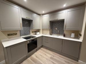 a kitchen with white cabinets and white counter tops at Townhouse in Shaftesbury