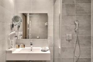a bathroom with a sink and a shower at Grand Hôtel des Bains SPA in Fouras