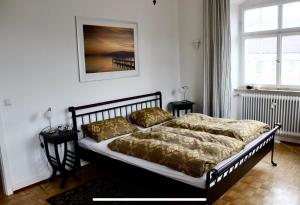 a bedroom with a bed with gold comforter at FeWo Seliger am Schloßplatz in Meersburg