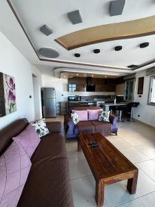 a living room with couches and a table and a piano at Fnideq Seaside Apartment in Fnidek +47 photos