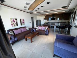 a living room with couches and a table and a kitchen at Fnideq Seaside Apartment in Fnidek