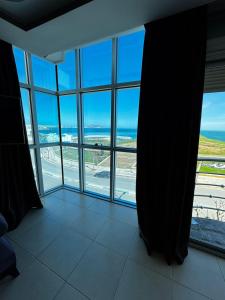 a room with a large window with a view of the ocean at Fnideq Seaside Apartment in Fnidek