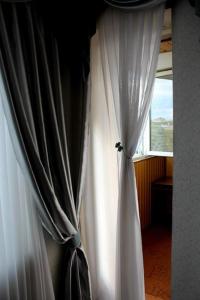 uma cortina branca num quarto com uma janela em Apartment On Prospekt Kirova em Dnipro