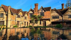 a large brick building with water in front of it at The Windsor Courtyard in Windsor